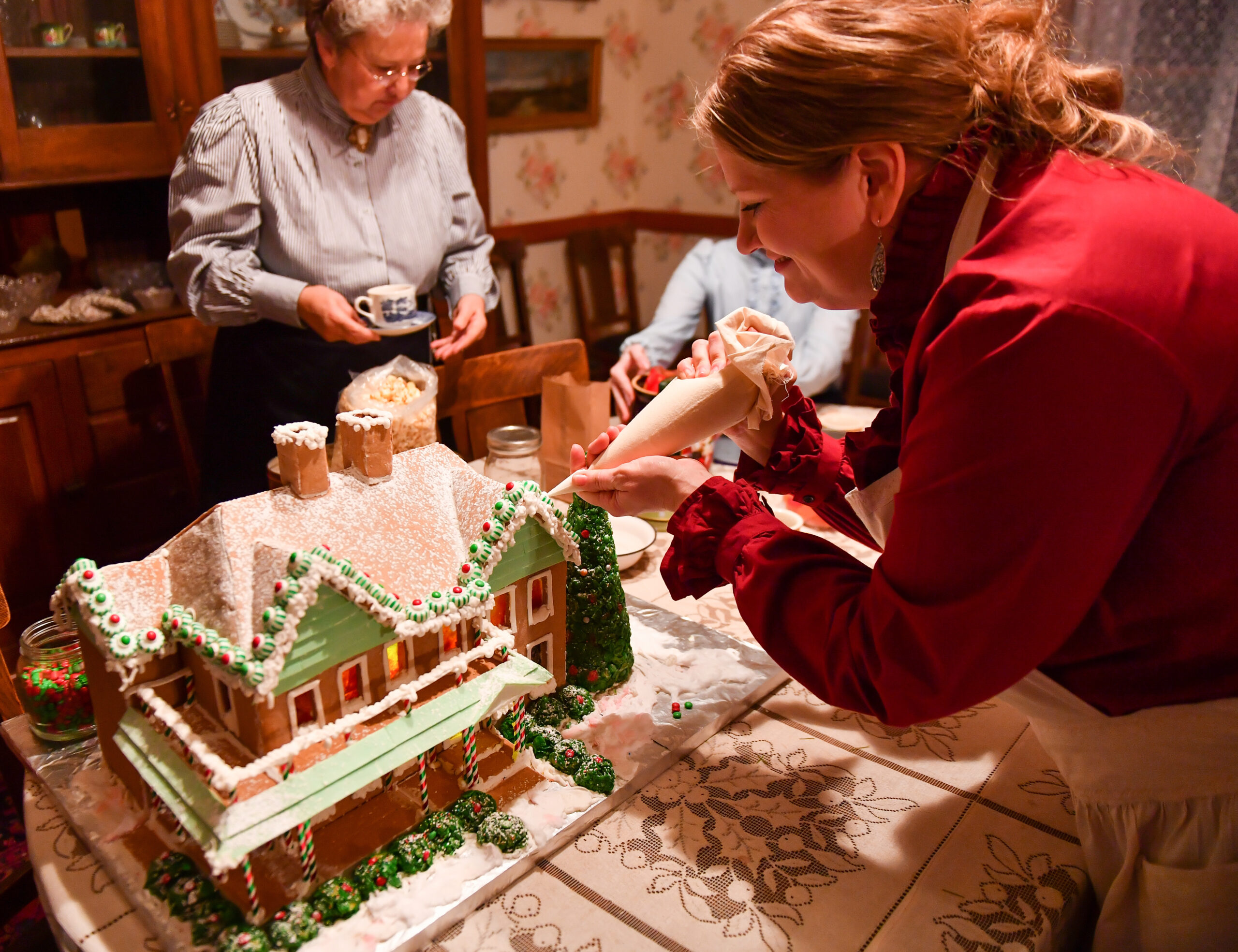 Decorating a gingerbread house during Candlelight at the Ranch.