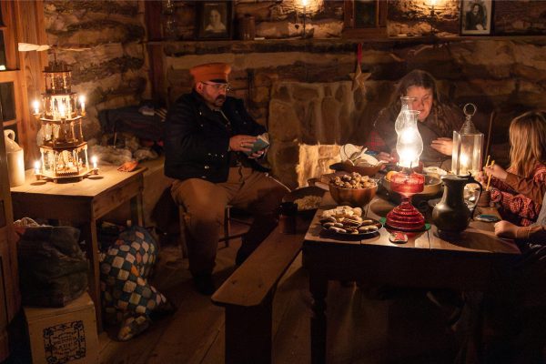 A volunteer family partaking in German Christmas activities in Hedwig's Hill dogtrot house.