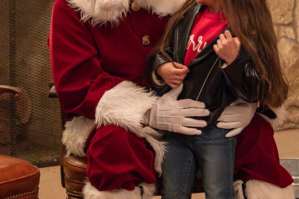 A young girl smiling at Santa Claus.