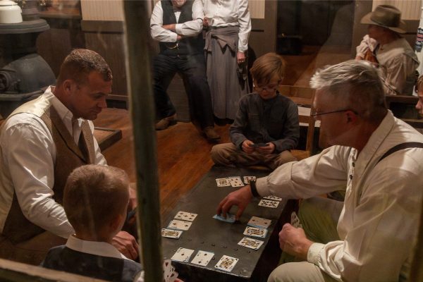 A group of fathers and sons play cards inside the Ropes Depot.