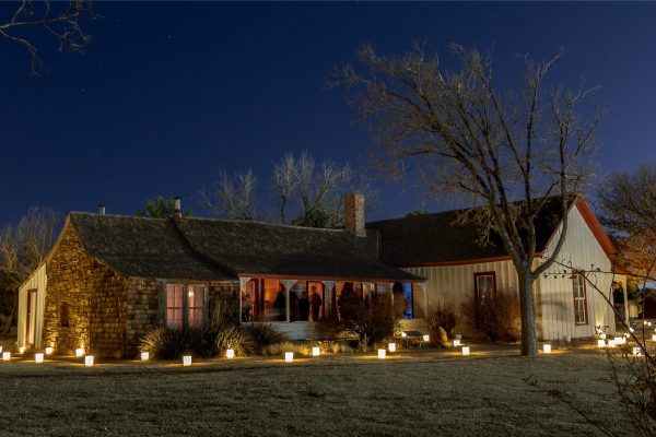 The Harrell House from the early 1900s and pathways lit with luminaries out front.
