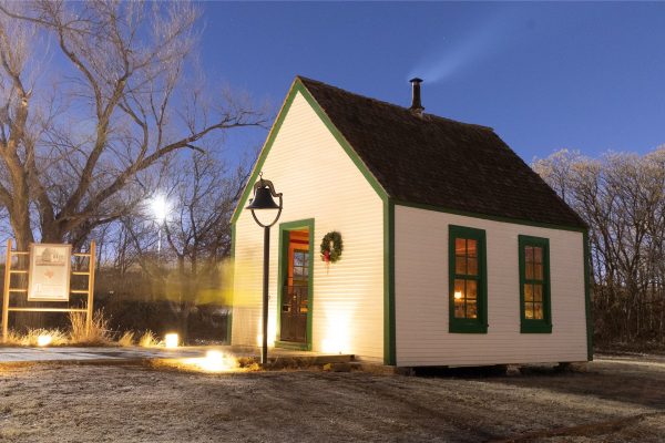 The Bairfield Schoolhouse is a white one-room building with green trim.