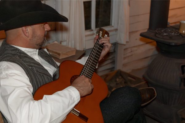 A cowboy playing the guitar.