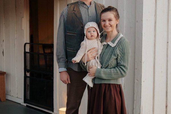 A young family with their baby outside the box and strip house.
