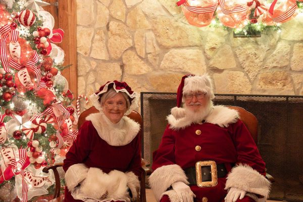 Santa Claus and Mrs. Claus inside a a decorated pavilion.