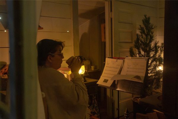 A woman reads music while drinking coffee.