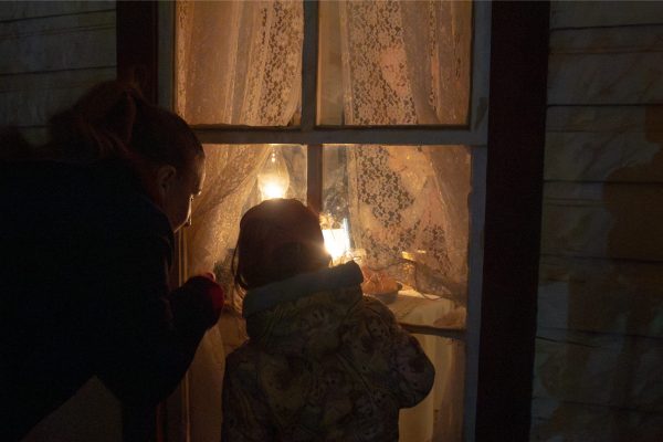Two visitors peak inside a window.