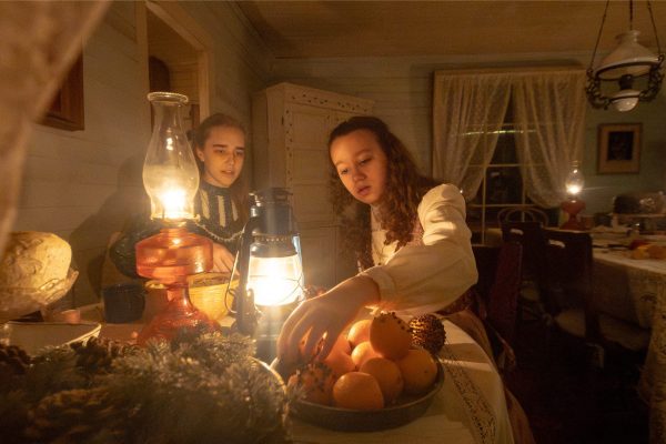 Two young girls decorate with fruit in the Harrell House.