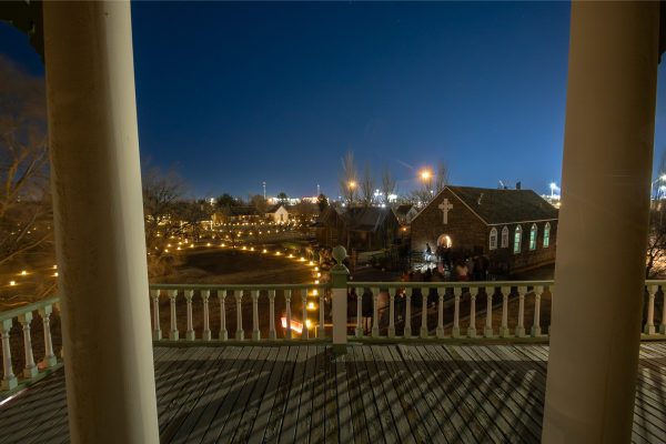 Crowd of people walking along lit pathways during Candlelight at the Ranch.